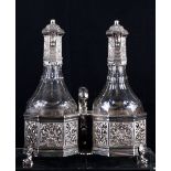 An early Victorian oil and vinegar glass and silver cruet with pierced decoration on four dolphin
