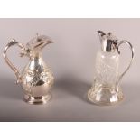 A cut glass claret jug with silver plated mounts and a plated and embossed claret jug