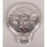 A silver hand mirror decorated with cherubs by William Comyns
