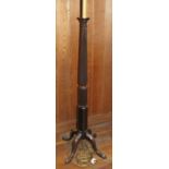 A mahogany standard lamp formed as a reeded column, on quadruple splay supports