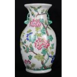 An oriental inspired pottery vase decorated with blue, pink, yellow, orange and purple flowers,