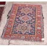 A Caucasian rug decorated central hooked medallion and two other medallions on a navy blue ground