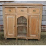 A waxed pine dresser base, fitted three drawers over two cupboards and central recess, 48" wide