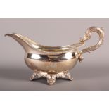 A silver gravy boat with gadroon edge on four shell decorated feet, 7.1oz troy approx