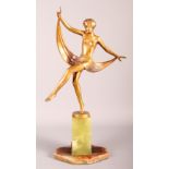 An Art Deco bronze figure of a dancer in a stretched pose holding a scarf covering her midriff, on a