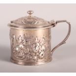 A Victorian silver mustard pot with embossed decoration and blue glass liner, 3.4oz troy approx