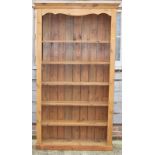 A pine bookcase with shaped frieze, fitted five shelves, on block base, 44" wide