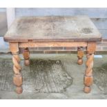 An early 20th Century oak rectangular wind-out dining table with centre leaf, on spiral turned