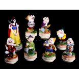 A set of Schmidt ceramic figures of Snow White and the Seven Dwarfs, bases fitted musical boxes, and