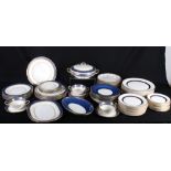 A set of twelve Aynsley dessert plates with blue and gilt edges, centres painted flowers, and an