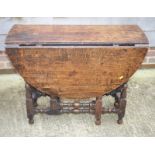 An early 18th Century oak oval drop leaf dining table, on gateleg turned and stretchered supports,