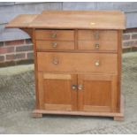 A mid 20th Century oak side cabinet with flap top, fitted two shallow, one deep and one long