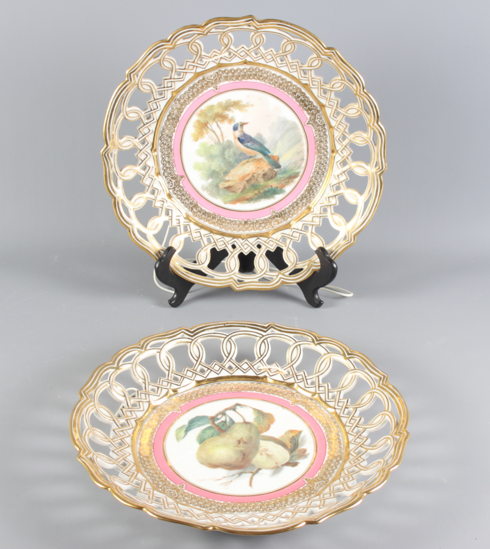 A pair of 19th Century reticulated porcelain chargers, gilt decoration with fruit and bird painted