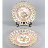 A pair of 19th Century reticulated porcelain chargers, gilt decoration with fruit and bird painted