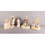 A pair of German porcelain figures of musicians by a tree, a German figure group of two ladies in