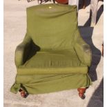 A late 19th Century fully upholstered armchair fitted green loose cover