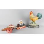 A modern painted metal cockerel door stop, a brass cannon on wooden carriage and a modern clown