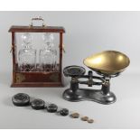 A set of scales with brass pans, a set of weights and a modern two-bottle tantalus