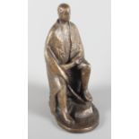 A modern unsigned bronze sculpture of a seated man with one leg raised, 12" high