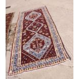 A Caucasian design rug, decorated three lozenge-shaped medallions and stylised flowers and animals