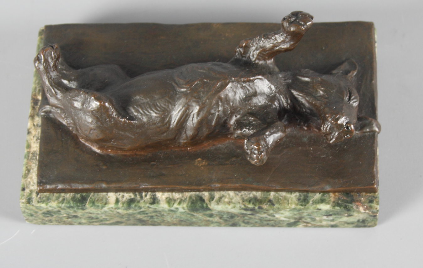 An unsigned bronze sculpture of a dog lying on its back, on green marble base, 5 1/2" x 3", and a