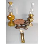 A moulded brass pedestal oil lamp, a brass pedestal oil lamp, a set of kitchen scales with weights