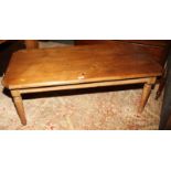 A waxed pine coffee table with canted corners, on turned and tapering supports, 48" long
