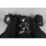 A policemens' cloak, a jacket, two helmets and a pair of handcuffs