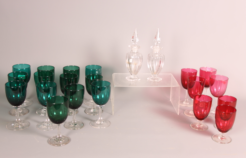 A collection of twenty wine glasses with ruby and green bowls and a pair of hexagonal glass scent