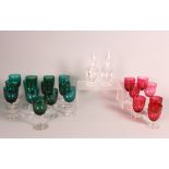 A collection of twenty wine glasses with ruby and green bowls and a pair of hexagonal glass scent