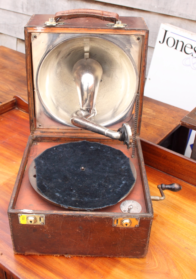 A portable gramophone by the Gramophone Company, leather covered case with lid inset hemispherical