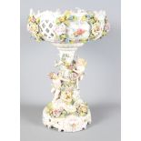 A 19th Century Sitzendorf style floral encrusted tablecentre, central stem decorated two cherubs,