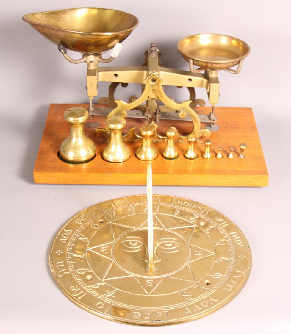 A set of brass scales with weights on wooden base and a brass sundial, 10" dia