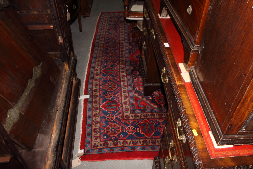 A Turkey carpet decorated central blue medallion and two subsidiary medallions on a red ground