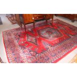 A Persian carpet decorated central blue and red octagonal medallion and two smaller lozenge