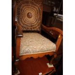 An early 20th Century open armchair with caned medallion back and floral tapestry seat cover