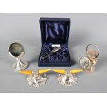 A pair of silver and ivory knife rests, a silver fob watch stand, a silver hat pin cushion and a