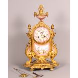 •A 19th Century Sevres style gilt metal cased clock with pink hand-painted porcelain panels and