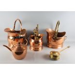 Two copper helmet coal scuttles, a copper kettle, a chestnut roaster and a fireside companion set