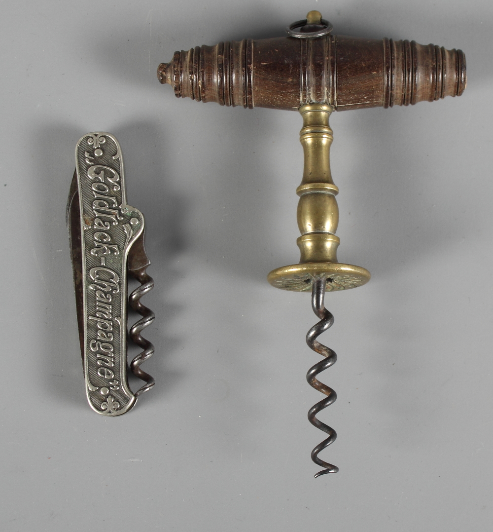 A brass corkscrew with turned wooden handle and a folding corkscrew advertising Goldtrack champagne