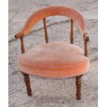 A late 19th Century low armchair with bow shaped top rail, upholstered in peach