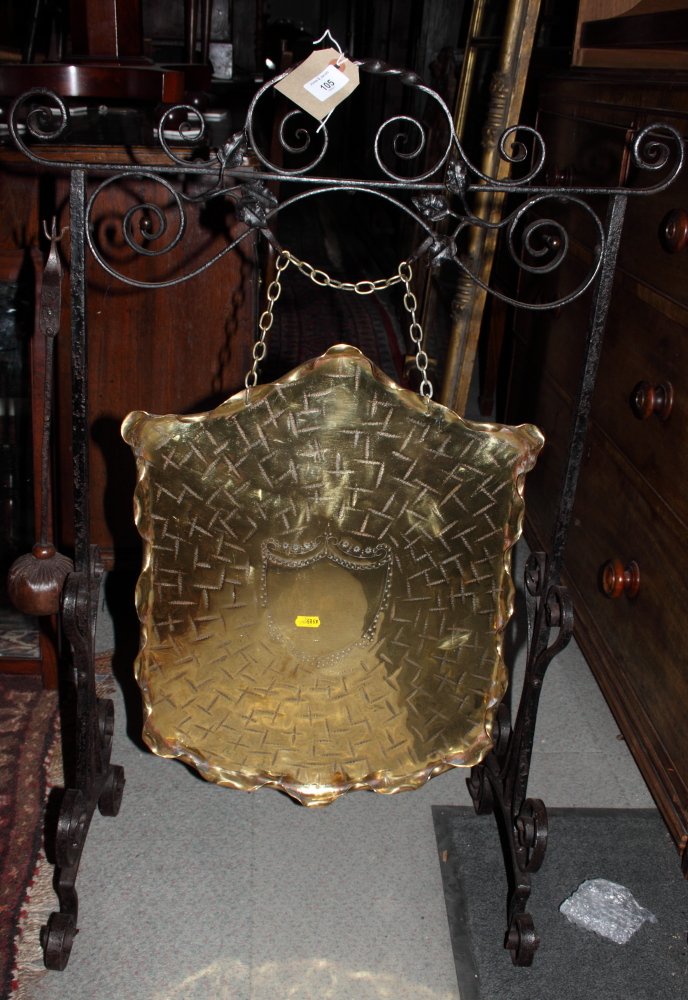 An Arts & Crafts wrought iron scrollwork and brass dinner gong