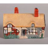 A W H Goss model of Ann Hathaway's Cottage (chip to edge) and a pair of Staffordshire seated
