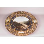 A 19th Century French pottery charger hand-painted mountain landscape with river, bridge and cattle,