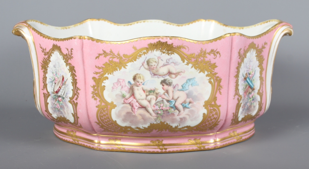 A Sevres porcelain jardiniere decorated reserves of flowers, putti and musical instruments on a pink