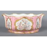 A Sevres porcelain jardiniere decorated reserves of flowers, putti and musical instruments on a pink