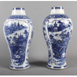 A pair of 18th Century Chinese porcelain blue and white vases with figures in landscape reserved