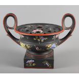 A Wedgwood black basalt encaustic decorated two handled urn decorated flowers on a black ground, 9