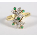 An 18ct gold floral design ring set diamonds and emeralds