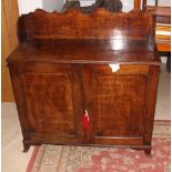 An early 19th Century mahogany low cupboard with shaped scalloped back board and reeded top enclosed